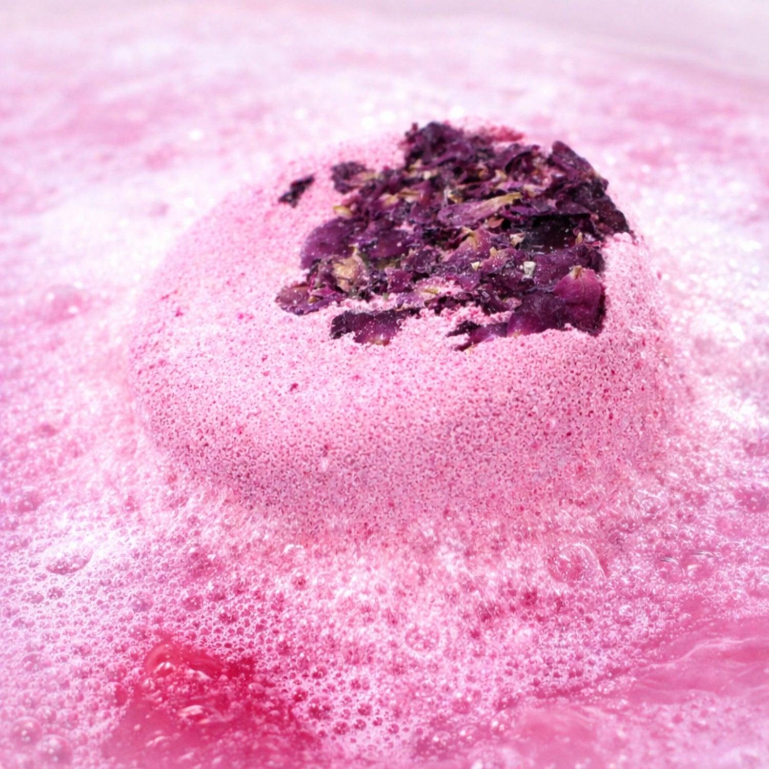 Pink rose bath fizzer gently fizzing in water, luxury bath bomb gift for her, relaxing pamper soak with dried rose petals