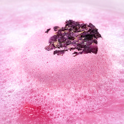 Pink rose bath fizzer gently fizzing in water, luxury bath bomb gift for her, relaxing pamper soak with dried rose petals