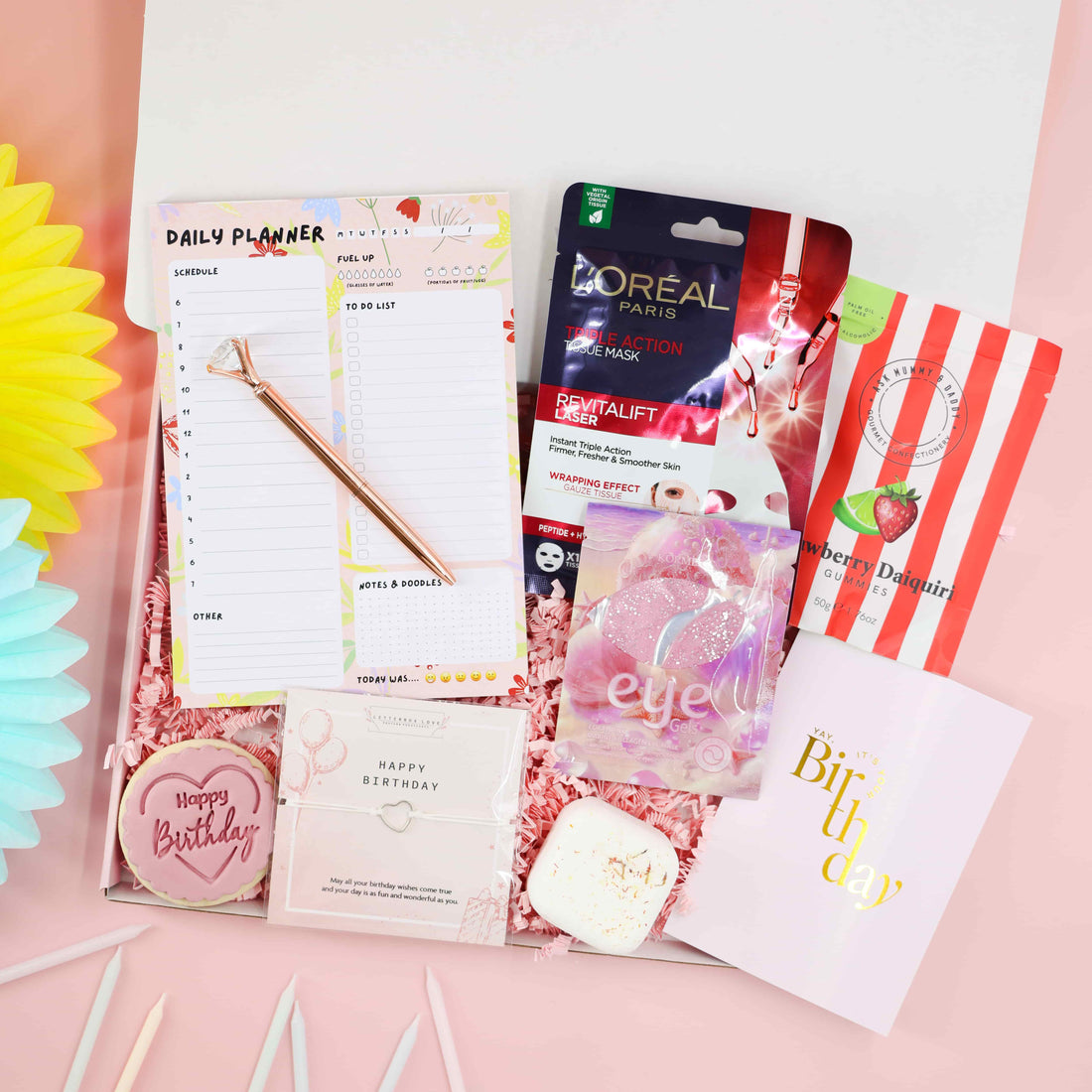 Self-Care Birthday Pamper Set – pink birthday gift box with planner, rose-gold pen, face mask, eye gels, strawberry daiquiri gummies, wish bracelet and iced biscuit by Heavenly Boxes