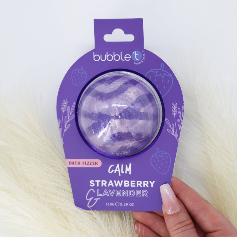 Calm Strawberry &amp; Lavender Bath Fizzer held in hand, promising a soothing bath experience with its calming fizz, infused with lavender and strawberry scents.