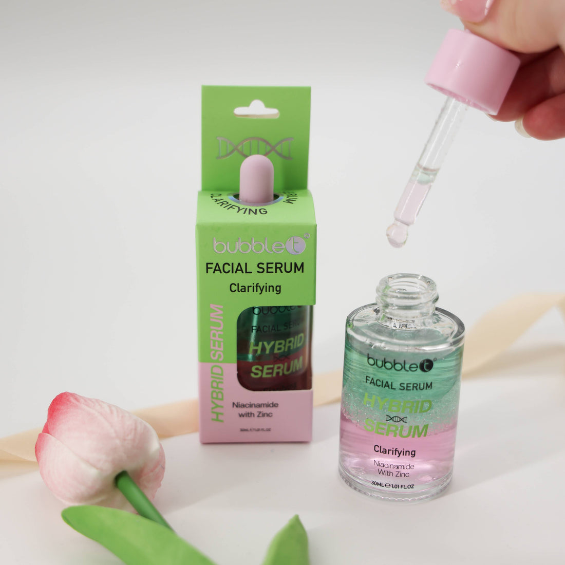 Bubble T Clarifying Facial Serum with niacinamide and zinc; a hand uses a dropper, emphasizing its lightweight, skin-brightening formula alongside its packaging.