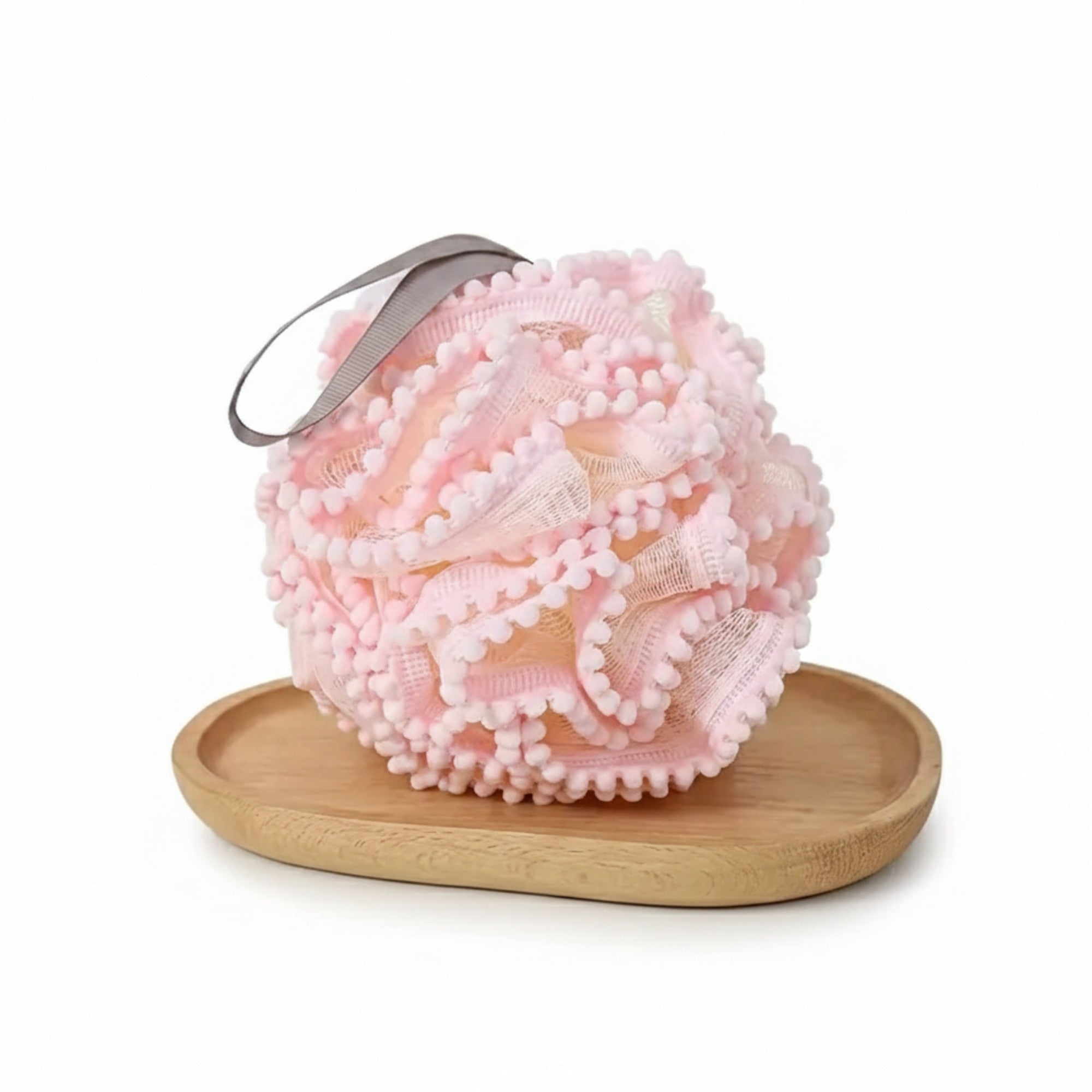 Luxury Loofah - Pink displayed on a wooden dish, showcasing its soft texture designed for gentle exfoliation and a rich, luxurious lather experience.