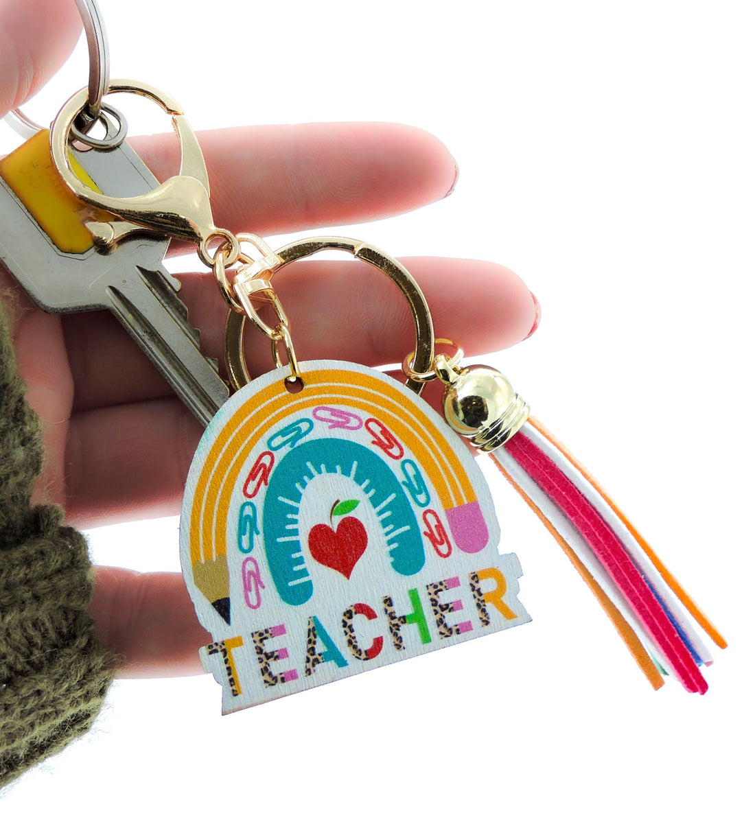 Hand holding Teacher Keyring with pencil and apple motifs, a playful design ideal for adding flair to keys or bags.