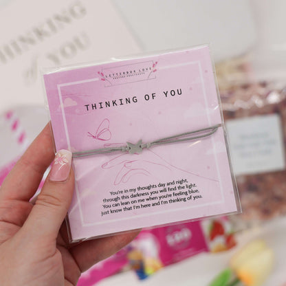 Thoughtful care package with wish bracelet, bath salts, and popcorn
