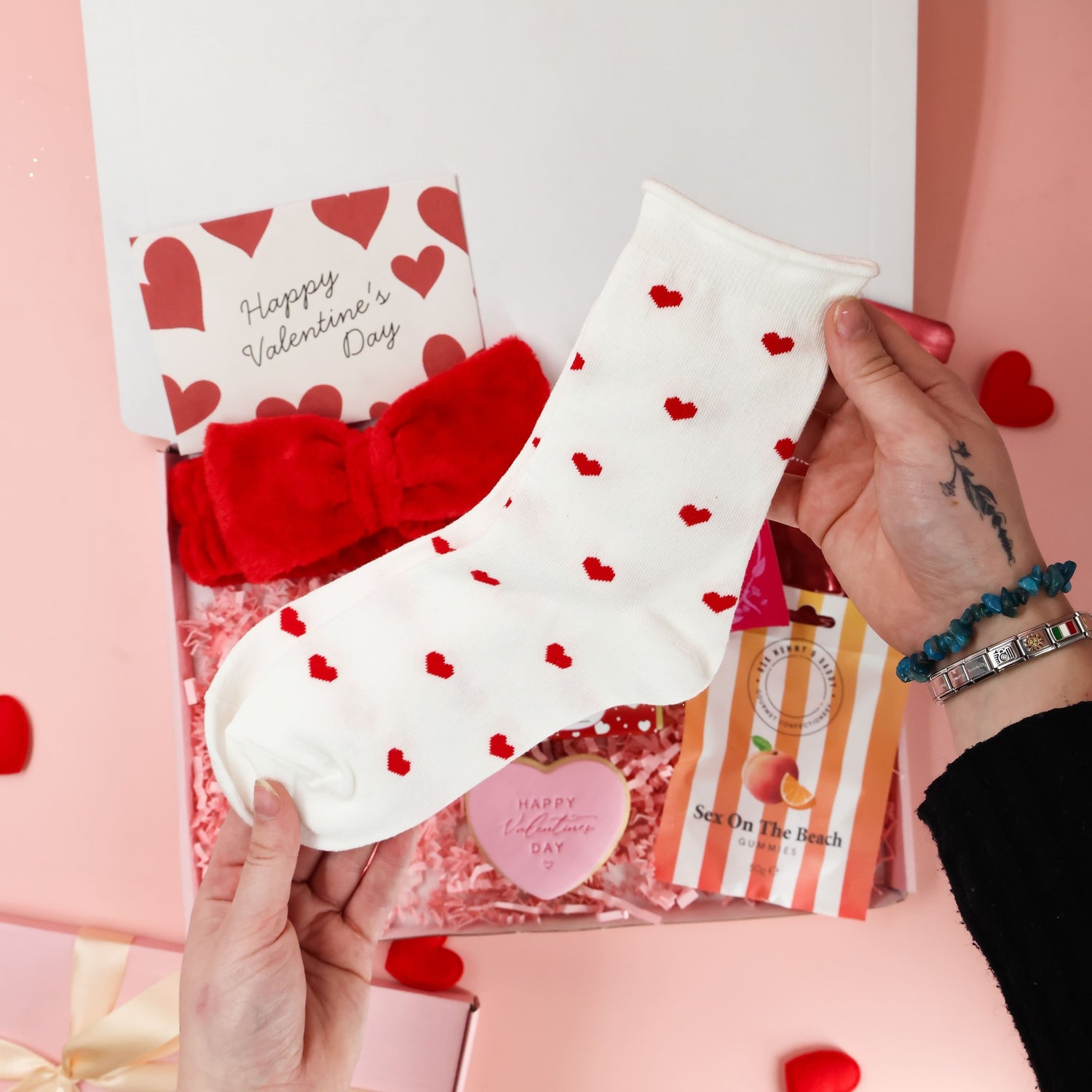 Valentines gift for her featuring heart socks, Valentine cards, gummies and pampering essentials
