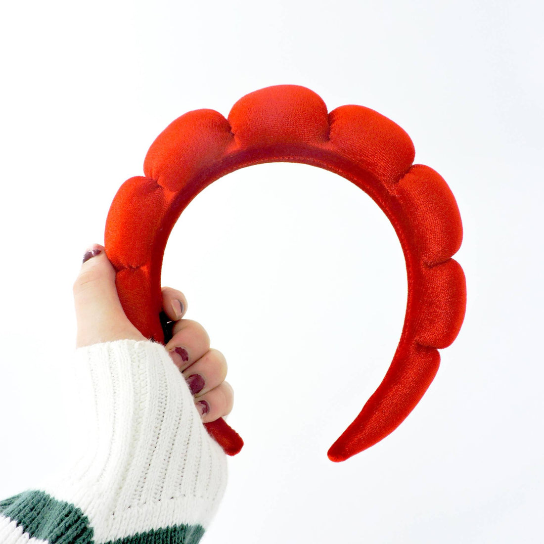 Hand holding the Velvet Headband - Red, highlighting its soft polyester texture, perfect for adding elegance to everyday hairstyles or beauty routines.