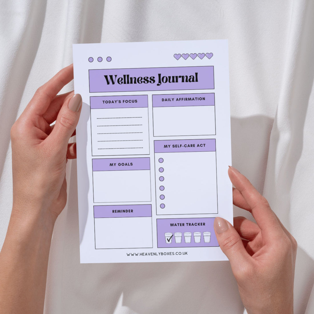 A hand holds a Wellness Journal, highlighting its compact size ideal for daily reflection, goal setting, and self-care tracking.
