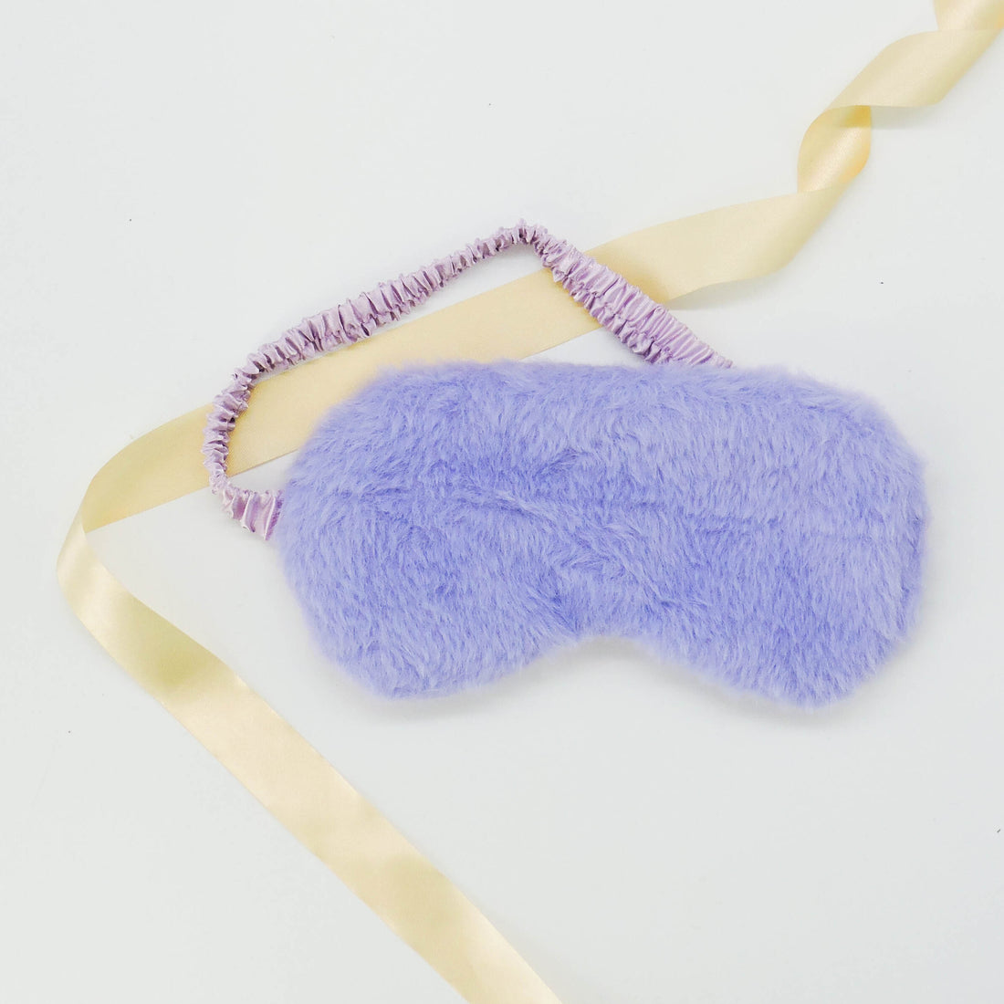 Plush Eye Mask Purple with a ruffled texture, complemented by a decorative ribbon, designed for luxury and relaxation in gift sets.